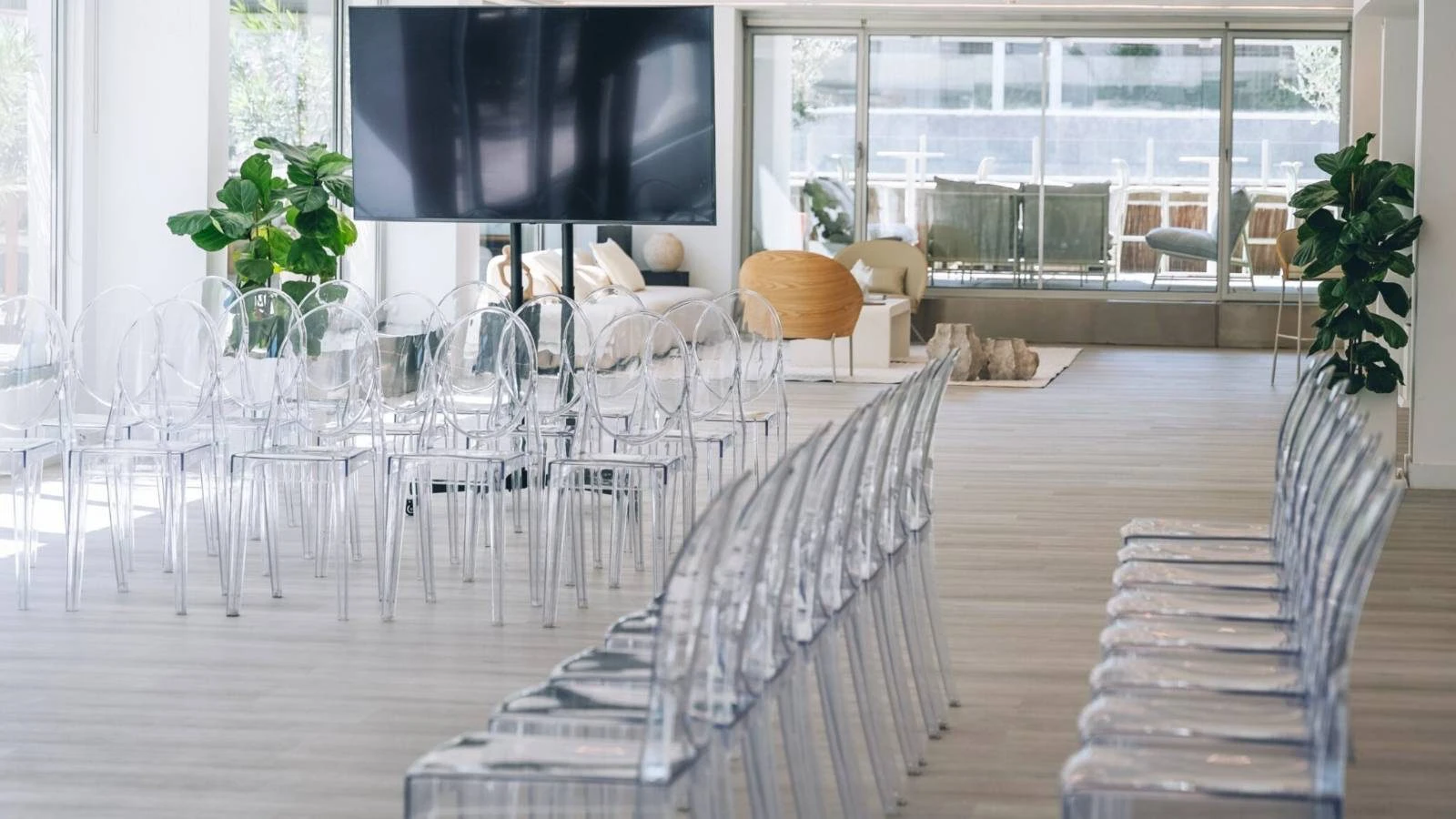 Sala luminosa con filas de sillas transparentes frente a una pantalla en Madrid