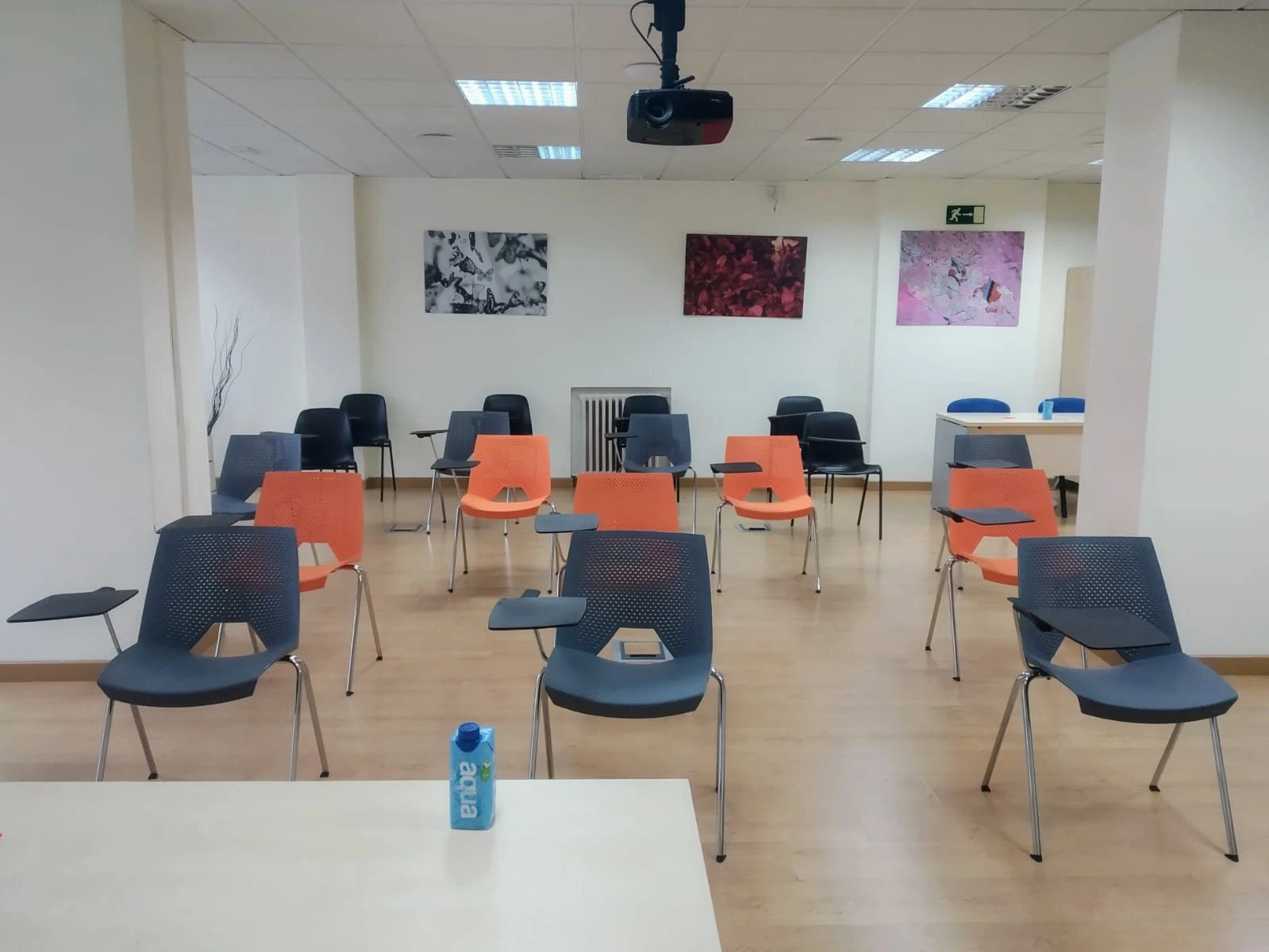 Aula con sillas con pala y proyector para una formación en Madrid