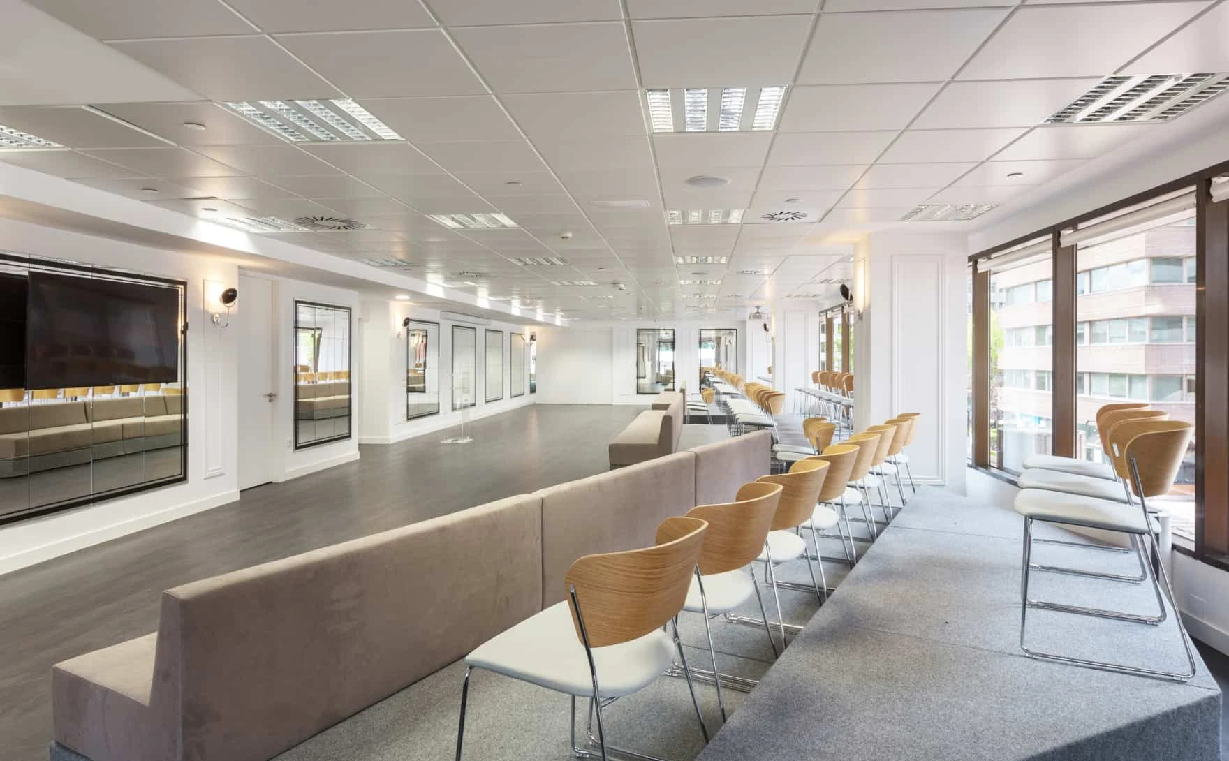 Sala amplia con gradas, pantalla y ventanales en Madrid