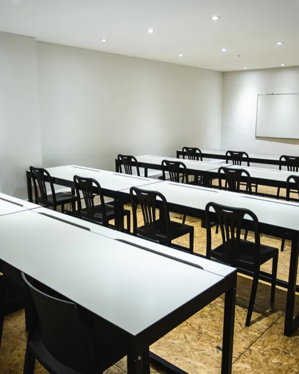 Sala de capacitación con mesas largas en fila y pizarra, en Villa Crespo, Buenos Aires