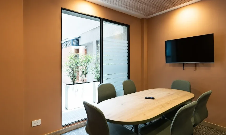 Sala de juntas para equipos pequeños con mesa ovalada y televisor en Bogotá