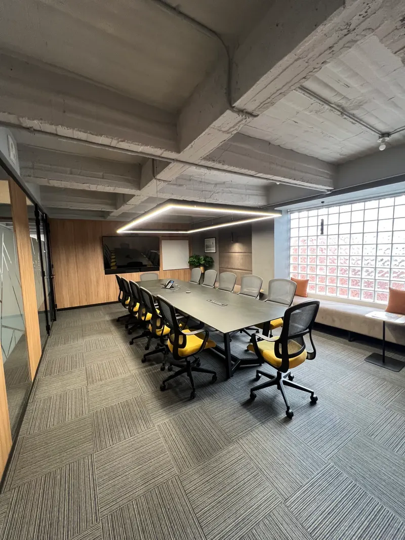 Sala de juntas con mesa larga y sillas amarillas en FW, Bogotá