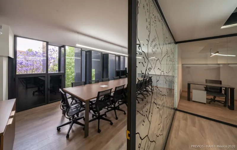 Sala de juntas larga con jacarandas en la ventana