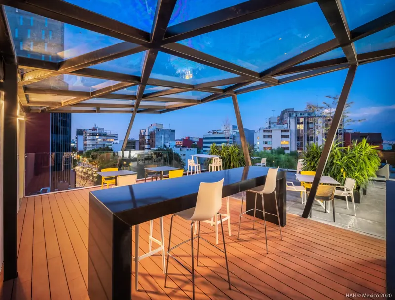 Terraza con mesas altas en CDMX al atardecer